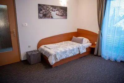 a small bed in a room with a window at B&B Brezov Gaj in Kranjska Gora