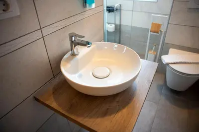 a white sink in a bathroom with a toilet at B&B Brezov Gaj in Kranjska Gora