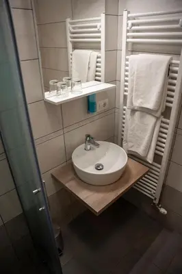 a bathroom with a sink and a mirror and towels at B&B Brezov Gaj in Kranjska Gora
