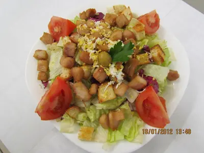 a white plate with a salad with tofu and tomatoes at Črni Baron Pension Black Baron in Maribor