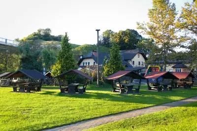 a park with benches and a playground in the grass at Črni Baron Pension Black Baron in Maribor