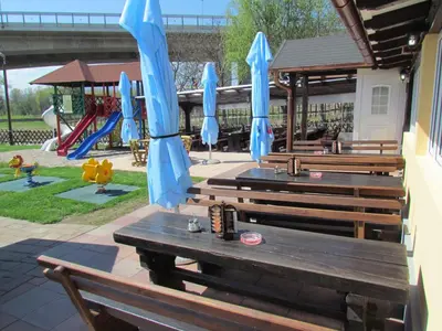 a group of benches with blue umbrellas and a playground at Črni Baron Pension Black Baron in Maribor