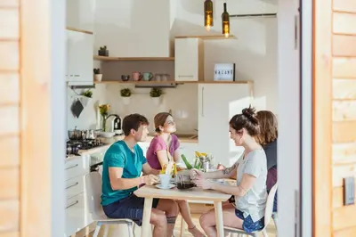 a group of people sitting around a table in a kitchen at Naturasort Holiday Houses in Pesnica pri Mariboru