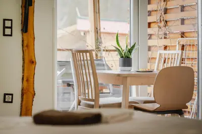 a table and chairs in a room with a window at Naturasort Holiday Houses in Pesnica pri Mariboru