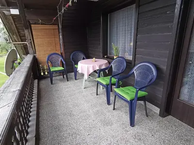 a patio with chairs and a table on a porch at Apartment and room Mateja Kovačič in Bohinj