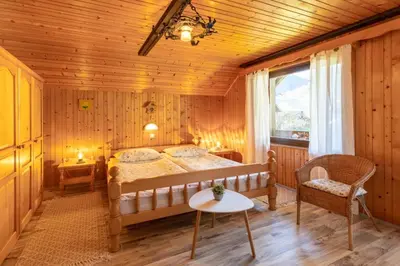 a bedroom with a bed and a table and a chair at Apartment and room Mateja Kovačič in Bohinj
