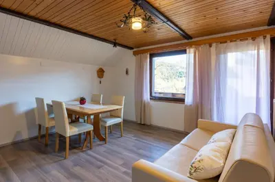 a living room with a couch and a table at Apartment and room Mateja Kovačič in Bohinj