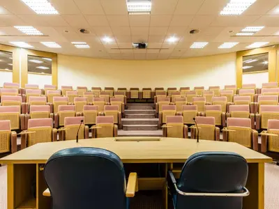 an empty lecture hall with a table and chairs at Hotel Piramida in Maribor