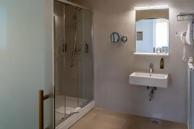 a bathroom with a shower and a sink at Hotel Piramida in Maribor