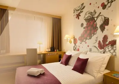 a hotel room with a bed with a towel on it at Hotel Piramida in Maribor