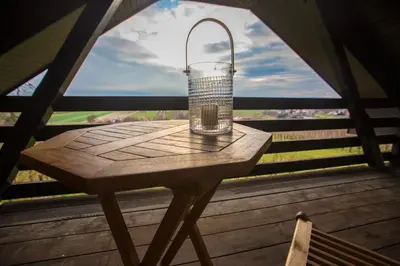 a lantern sitting on a wooden table on a porch at Vineyard Living in Filovci