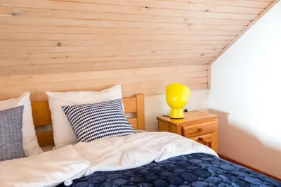 a bedroom with a bed and a yellow lamp on a night stand at Vineyard Living in Filovci
