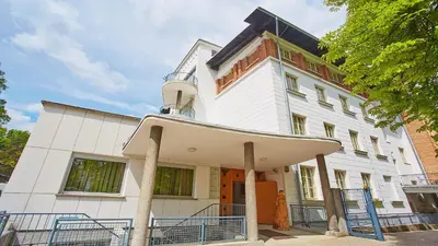a white building with an archway in front of it at Saint Ignatius Retreat House in Ljubljana