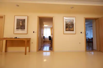 a room with a desk and paintings on the wall at Saint Ignatius Retreat House in Ljubljana