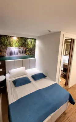 a bedroom with a bed with a painting on the wall at Hotel Emonec in Ljubljana