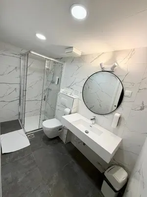a bathroom with a sink and a toilet and a mirror at Hotel Emonec in Ljubljana