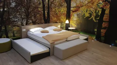 a bedroom with a bed and two chairs and a table at Hotel Emonec in Ljubljana