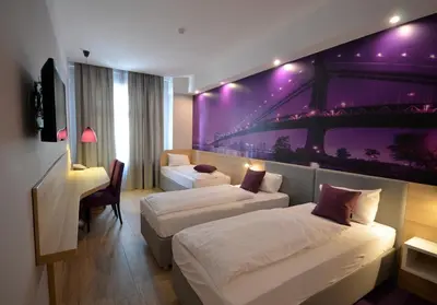 a hotel room with two beds and a desk at Hotel Emonec in Ljubljana