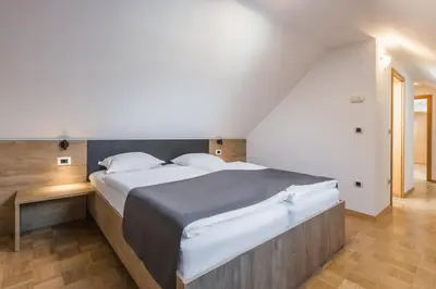a bedroom with a large bed and a staircase at Török rooms, bistro & wellness in Lesce