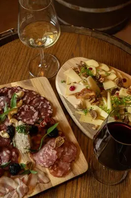 a table with two plates of food and a glass of wine at Török rooms, bistro & wellness in Lesce