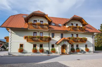 a large white building with flower boxes on it at Török rooms, bistro & wellness in Lesce