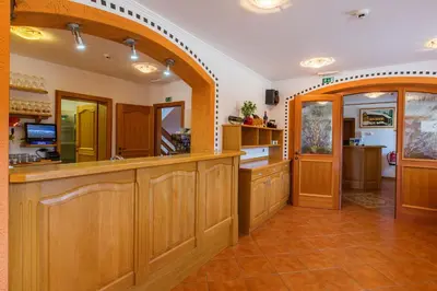 a large kitchen with wooden cabinets and a counter at Török rooms, bistro & wellness in Lesce
