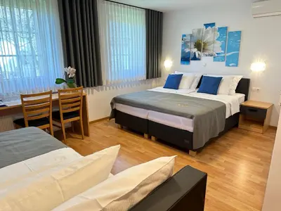 a hotel room with two beds and a table and chairs at Boutique Hotel Loka in Škofja Loka