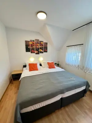 a bedroom with a large bed with two orange pillows at Boutique Hotel Loka in Škofja Loka