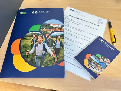 two pages of brochures on top of a table at Boutique Hotel Loka in Škofja Loka