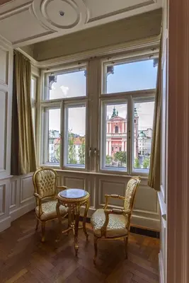 a room with two chairs and a table and windows at Filip’s Palace Luxurious Apartment in Ljubljana