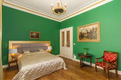 a bedroom with green walls and a bed and a chair at Filip’s Palace Luxurious Apartment in Ljubljana