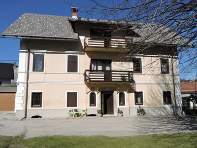 a large white building with a porch and balcony at Apartments Banko in Bled