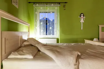 a bedroom with green walls and a bed with a window at Apartma Angelca in Kranjska Gora