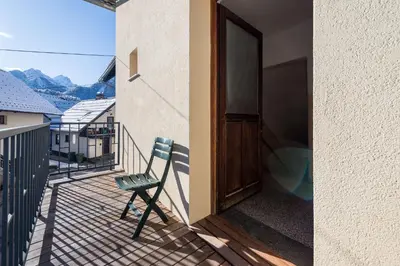 a chair sitting on the balcony of a house at Apartma Angelca in Kranjska Gora