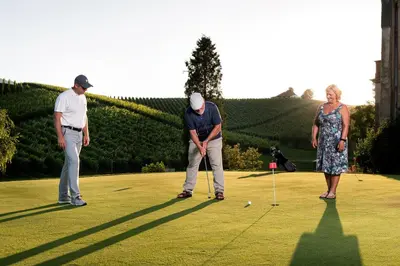two men and a woman playing a game of golf at Dvorec Trebnik - SOBE in Slovenske Konjice