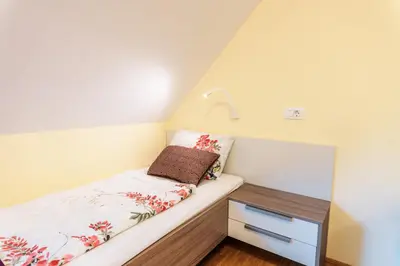 a small bedroom with a bed and a nightstand at Dvorec Trebnik - SOBE in Slovenske Konjice