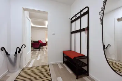 a hallway with a mirror and a red bench at Apartment Tivoli Park in Ljubljana