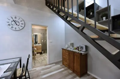 a staircase with a clock on the wall and a kitchen at Apartment Tivoli Park in Ljubljana