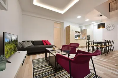 a living room with a couch and chairs and a table at Apartment Tivoli Park in Ljubljana