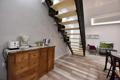 a kitchen with a wooden cabinet and a spiral staircase at Apartment Tivoli Park in Ljubljana