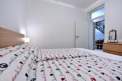 a bedroom with a bed with a red and white bedspread at Apartment Tivoli Park in Ljubljana