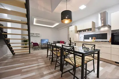 a kitchen and dining room with a table and chairs at Apartment Tivoli Park in Ljubljana