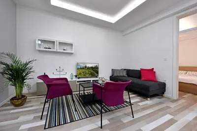 a living room with purple chairs and a couch at Apartment Tivoli Park in Ljubljana
