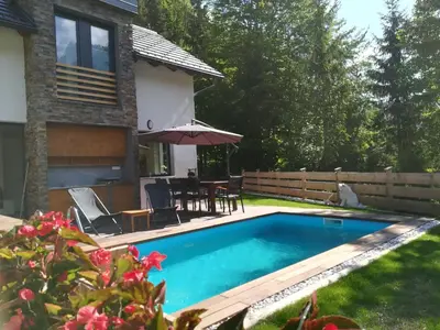 a swimming pool in the backyard of a house at Hiša Katja-Privat wellness in Kranjska Gora