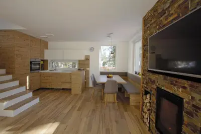 a kitchen and living room with a fireplace and a tv at Hiša Katja-Privat wellness in Kranjska Gora