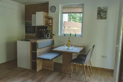 a small kitchen with a small table and chairs at Hiša Katja-Privat wellness in Kranjska Gora