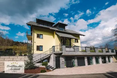 a large yellow building with a balcony at Bled Paradise Apartments in Bled
