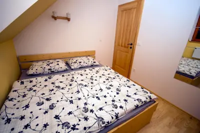 a bedroom with a bed with a blue and white comforter at Apartmaji Lajf in Kranjska Gora