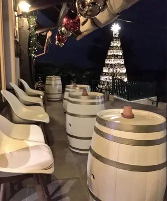 a row of wine barrels with a christmas tree in the background at Taverna & Wine Jeruzalem in Ivanjkovci