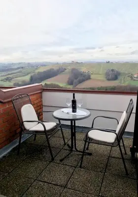 a table and two chairs on a balcony with a window at Taverna & Wine Jeruzalem in Ivanjkovci